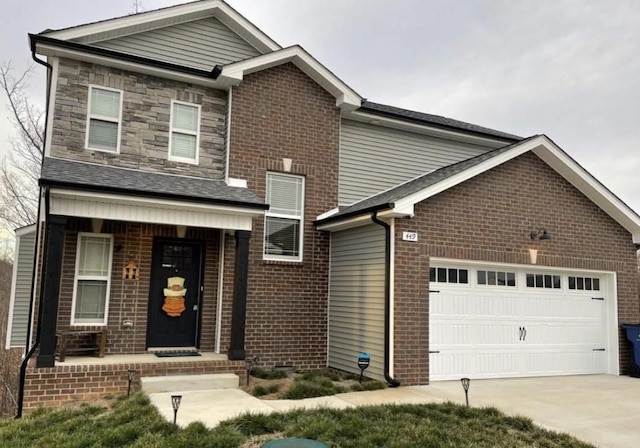 traditional home with a porch, an attached garage, concrete driveway, stone siding, and brick siding