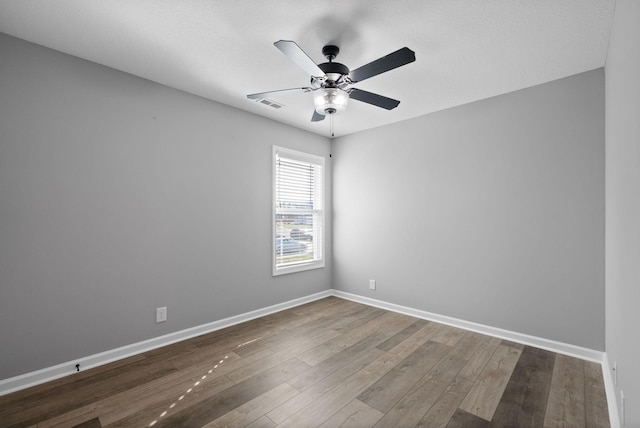 empty room featuring baseboards, visible vents, wood finished floors, and ceiling fan