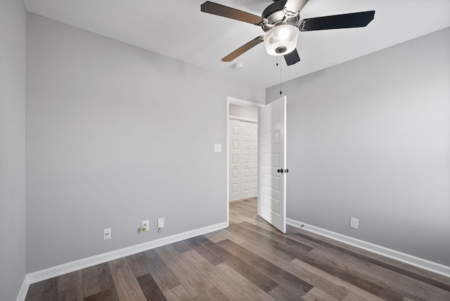 empty room with wood finished floors, baseboards, and ceiling fan