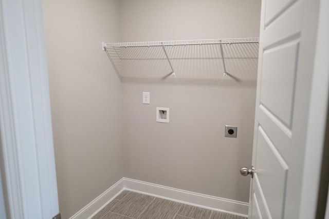 clothes washing area featuring baseboards, hookup for an electric dryer, hookup for a washing machine, and laundry area