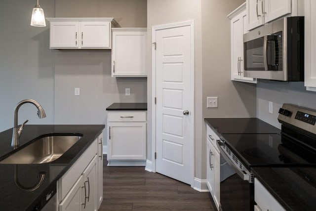 kitchen with a sink, white cabinets, dark wood finished floors, and stainless steel appliances