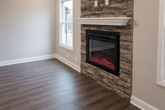 unfurnished living room featuring dark wood finished floors, a fireplace, and baseboards