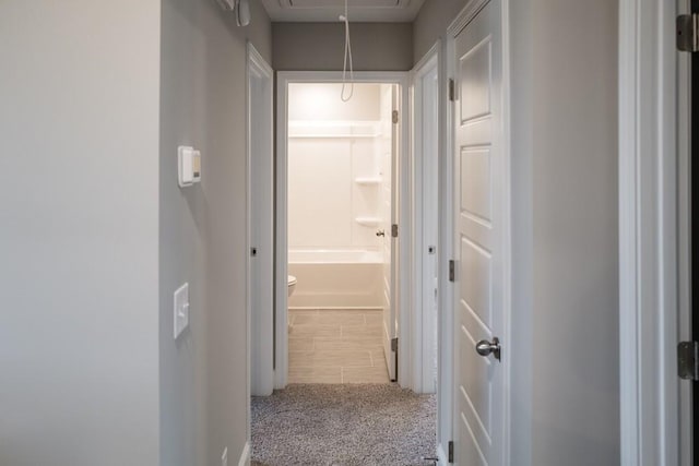 hallway with attic access and carpet floors