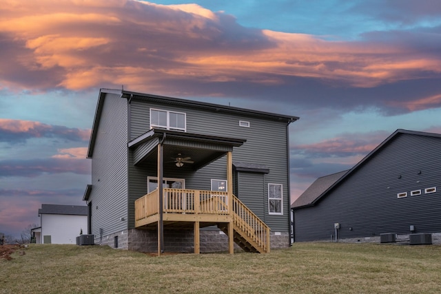 rear view of property featuring stairs, cooling unit, and a lawn