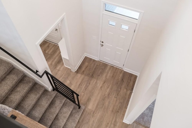 foyer featuring light wood-type flooring, baseboards, and stairs