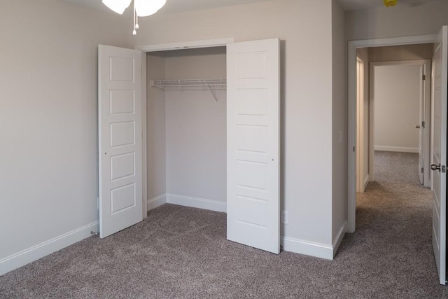 unfurnished bedroom with a closet, baseboards, and carpet