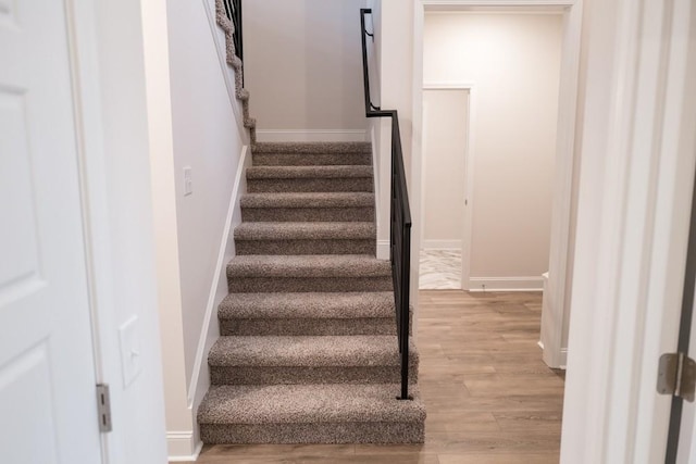 stairway featuring baseboards and wood finished floors