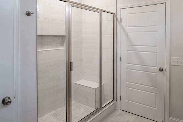 bathroom featuring a shower stall and wood finished floors