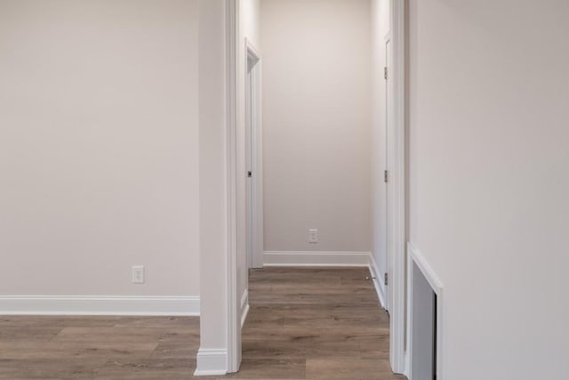 hallway with wood finished floors and baseboards