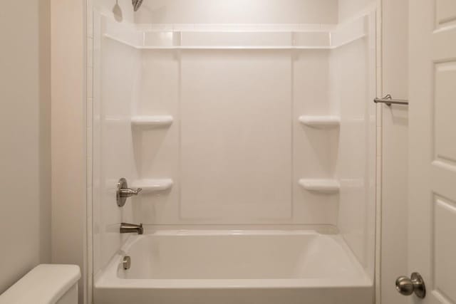 bathroom featuring shower / bath combination and toilet