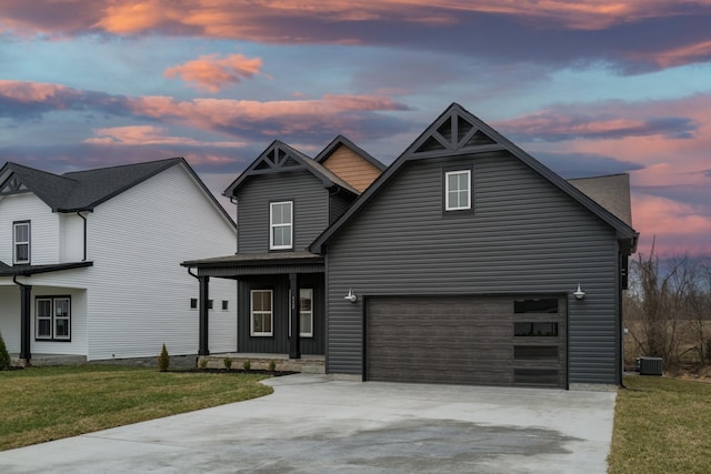 view of front of home with central air condition unit, covered porch, concrete driveway, and a front yard