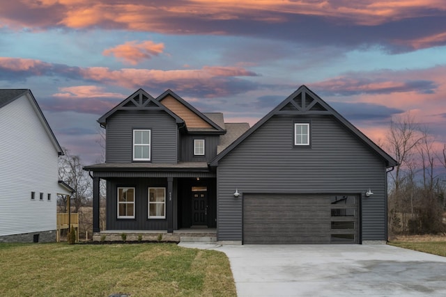 view of front of house featuring a porch, a garage, driveway, and a front lawn