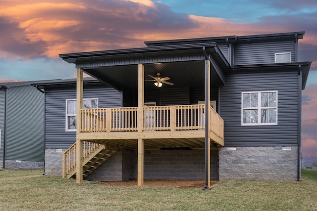 rear view of property featuring a deck, a yard, crawl space, a carport, and stairs