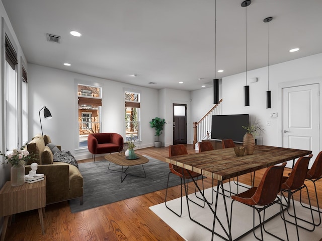 dining area featuring visible vents, light wood-style flooring, recessed lighting, baseboards, and stairs