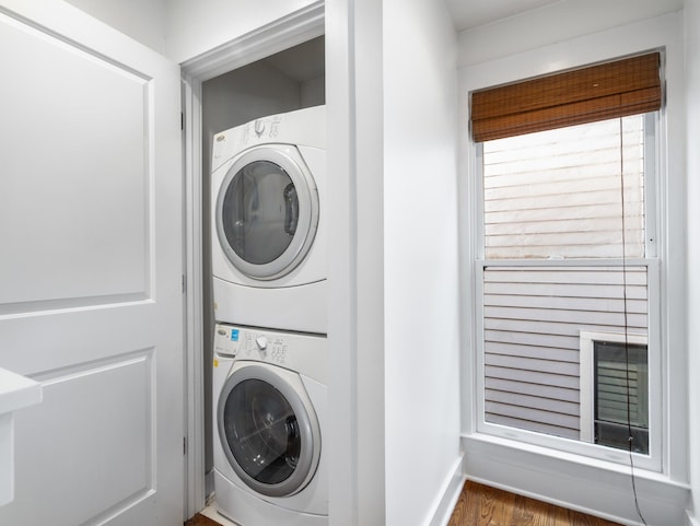 washroom with stacked washer / drying machine and laundry area