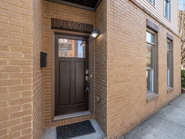 entrance to property featuring brick siding