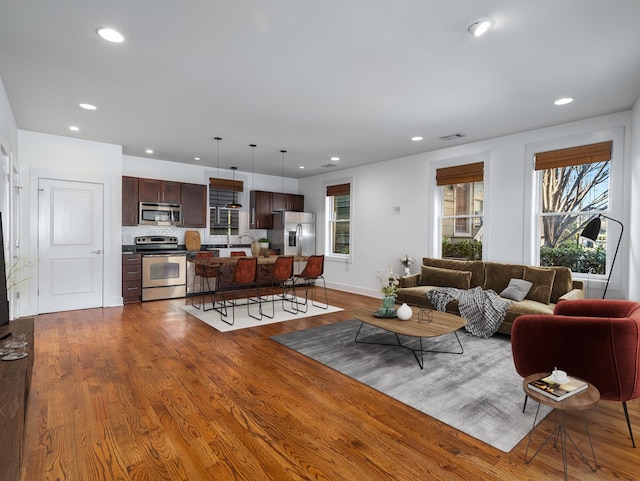 living room with dark wood-type flooring and recessed lighting