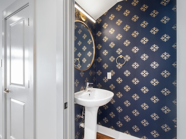 bathroom featuring baseboards and wallpapered walls