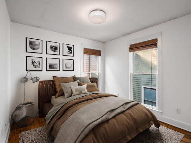 bedroom with baseboards, dark wood finished floors, and a fireplace