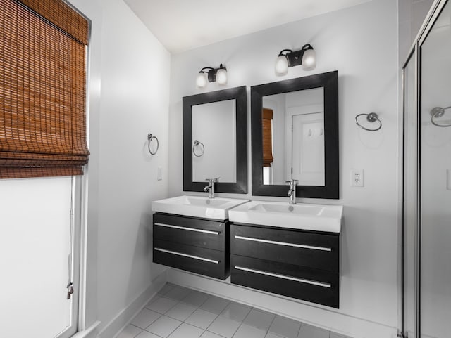 bathroom with a sink, baseboards, a stall shower, and double vanity