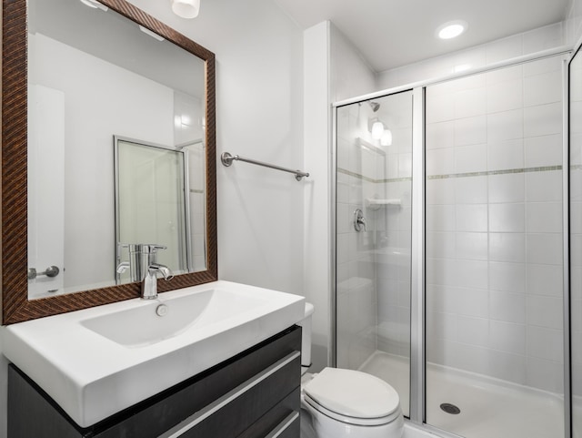 bathroom with vanity, toilet, and a shower stall