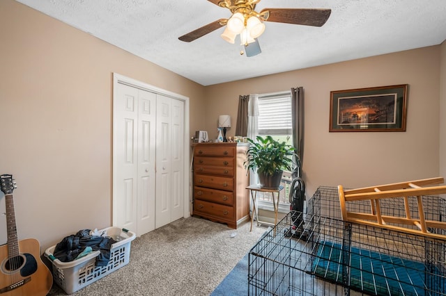 carpeted bedroom featuring a closet, a textured ceiling, and a ceiling fan