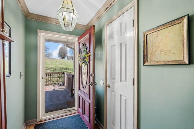 foyer with baseboards and ornamental molding