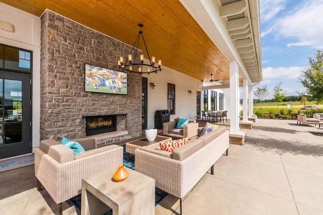 view of patio with an outdoor living space with a fireplace and a ceiling fan