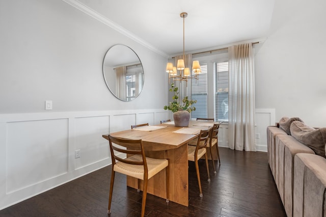 dining room featuring a wainscoted wall, a notable chandelier, dark wood-type flooring, crown molding, and a decorative wall