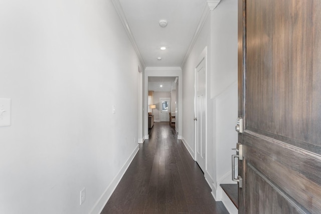 hallway with dark wood-type flooring, recessed lighting, baseboards, and ornamental molding