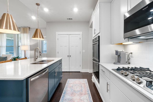 kitchen featuring dark wood-style floors, white cabinets, stainless steel appliances, blue cabinets, and a sink