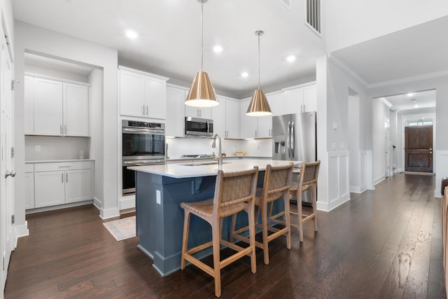 kitchen featuring visible vents, light countertops, dark wood-type flooring, appliances with stainless steel finishes, and a kitchen bar