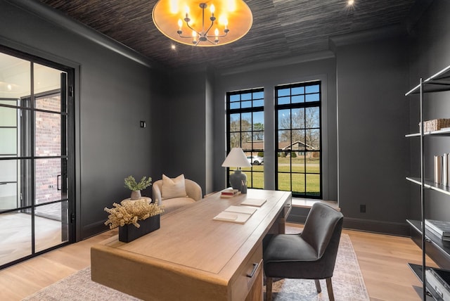 office featuring a notable chandelier, baseboards, and light wood-style floors