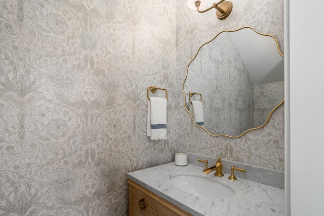 bathroom with wallpapered walls and vanity