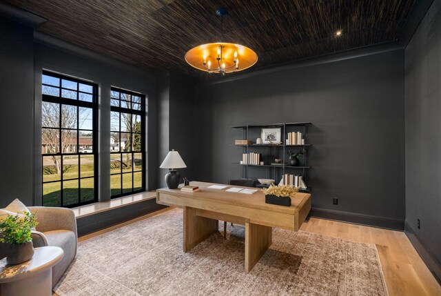 office featuring a chandelier, baseboards, and wood finished floors