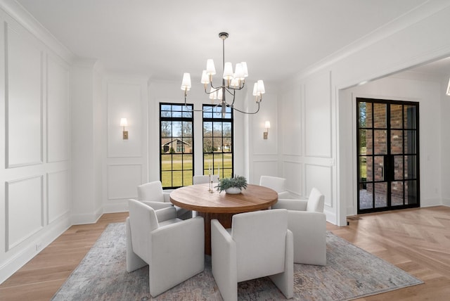 dining space with a decorative wall, an inviting chandelier, and ornamental molding