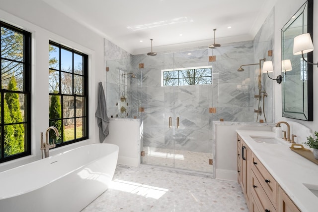 full bathroom featuring double vanity, a wealth of natural light, a marble finish shower, and a sink