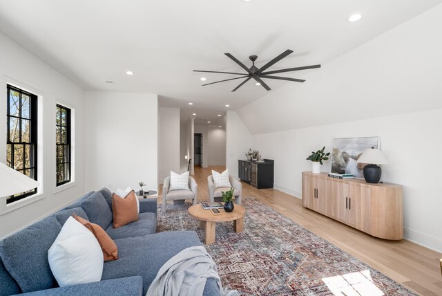 living area with recessed lighting, baseboards, lofted ceiling, and light wood-style floors