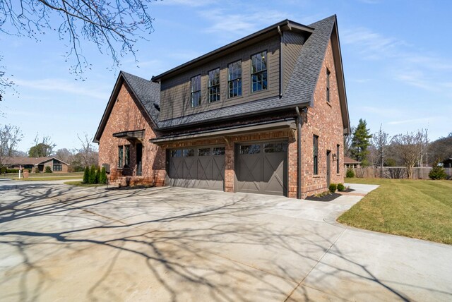 view of front of house with a front lawn, roof with shingles, concrete driveway, an attached garage, and brick siding