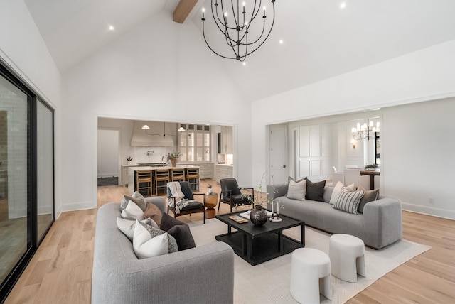 living room featuring beamed ceiling, a notable chandelier, high vaulted ceiling, light wood finished floors, and baseboards