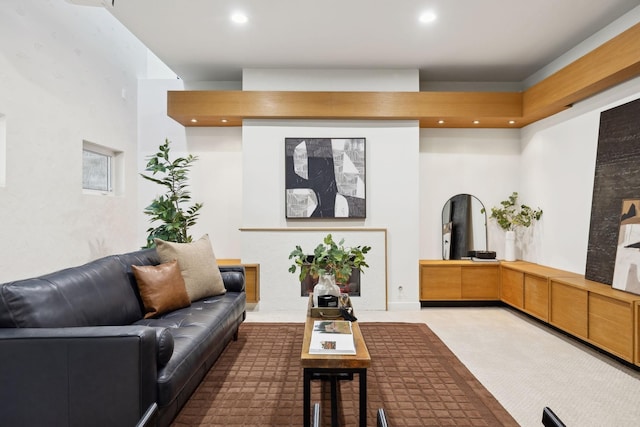 carpeted living room with recessed lighting and arched walkways