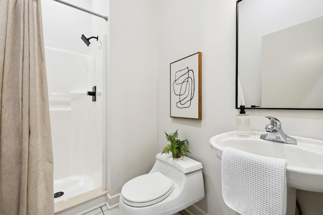 bathroom featuring a sink, toilet, and a stall shower