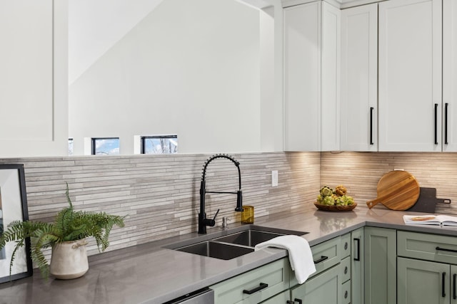 kitchen featuring a sink, backsplash, and white cabinets