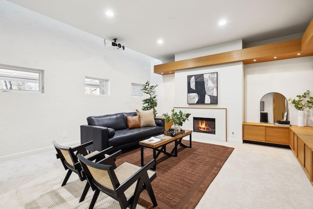 living room featuring recessed lighting, baseboards, carpet floors, and a lit fireplace