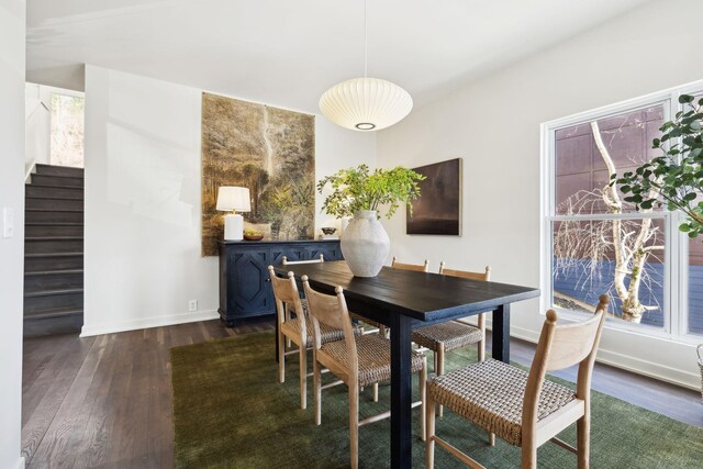 dining area featuring stairway, baseboards, and wood finished floors