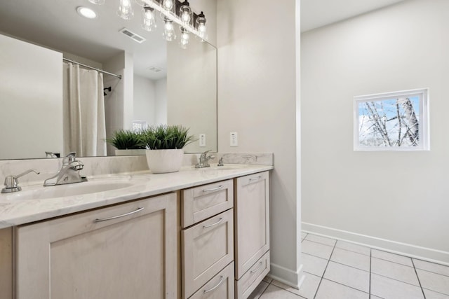 bathroom featuring a sink, visible vents, double vanity, and tile patterned floors