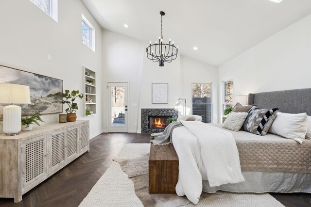 bedroom featuring access to exterior, recessed lighting, a tile fireplace, a notable chandelier, and high vaulted ceiling