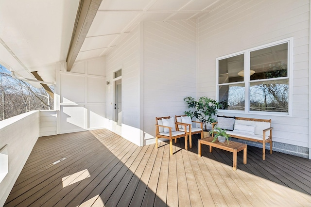 wooden terrace with an outdoor living space