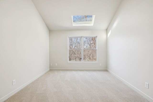 spare room with a skylight, baseboards, and carpet floors