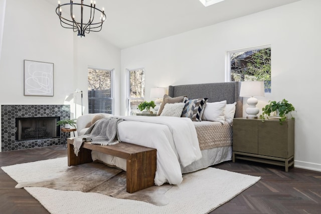 bedroom featuring an inviting chandelier, a fireplace, baseboards, and high vaulted ceiling